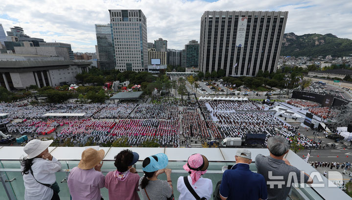 [서울=뉴시스] 김금보 기자 = 28일 서울 종로구 대한민국역사박물관 옥상정원에서 시민들이 '2024 국제선명상대회(불교도대법회)' 국민오계 수계법회가 열리고 있는 광화문광장을 내려다보고 있다. 2024.09.28. kgb@newsis.com