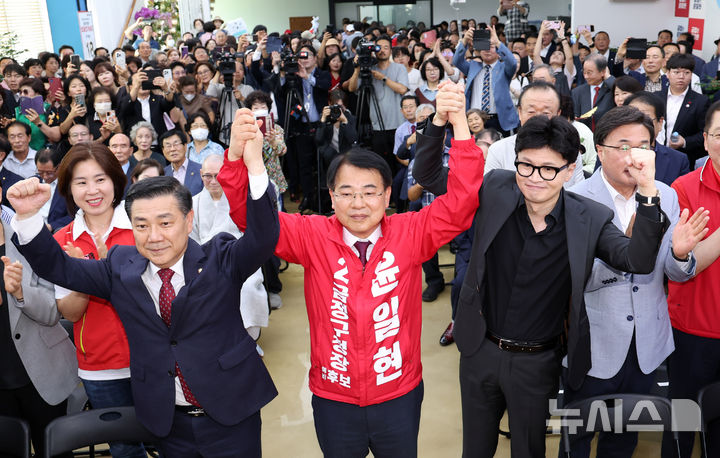 [부산=뉴시스] 하경민 기자 = 한동훈 국민의힘 대표가 28일 부산 금정구 윤일현 금정구청장 후보 선거사무실 개소식에 참석, 윤 후보의 손을 들고 지지를 호소하고 있다. 2024.09.28. yulnetphoto@newsis.com