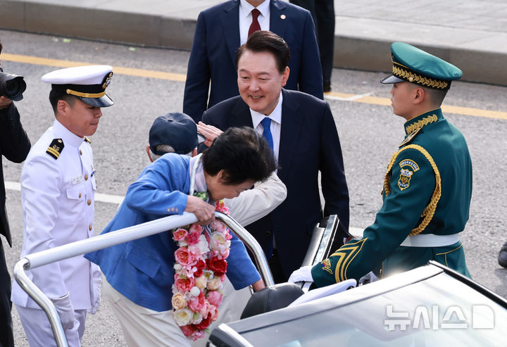 [서울=뉴시스] 최진석 기자 = 윤석열 대통령이 1일 서울 광화문 일대에서 열린 건군 76주년 국군의날 시가행진에서 카 퍼레이드를 마친 호국영웅인 송치선, 안상정 6.25 참전용사들을 맞이하고 있다. (대통령실통신사진기자단) 2024.10.01. myjs@newsis.com