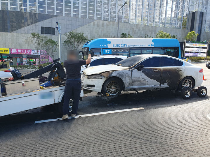 [부산=뉴시스] 2일 오전 부산 연제구 한 도로에서 A(40대)씨가 몰던 승용차에서 불이 났다. 불이 진화된 후 차량이 옮겨지고 있다. (사진=부산경찰청 제공) 2024.10.02. photo@newsis.com *재판매 및 DB 금지