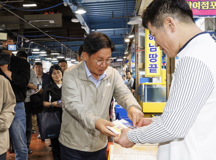 [서울=뉴시스]박강수 마포구청장이 마포농수산물시장에 방문해 상인에게 _안전한 여름철 수산물 즐기기_ 리플릿을 배부하고 있다. 2024.010.02. (사진=마포구 제공) *재판매 및 DB 금지