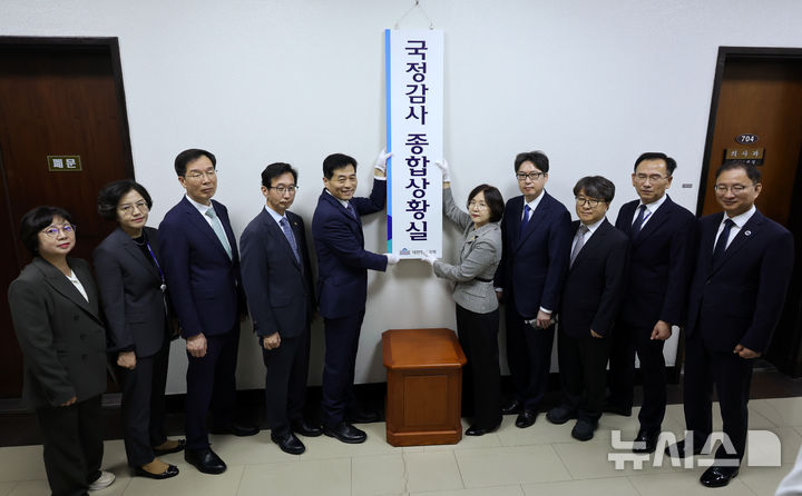 [서울=뉴시스] 국회사진기자단 = 2일 서울 여의도 국회에서 열린 국정감사 종합상황실 현판식에서 김민기(왼쪽 다섯 번째부터) 사무총장과 진선희 입법차장 등 참석자들이 현판을 걸고 있다. 2024.10.02. photo@newsis.com