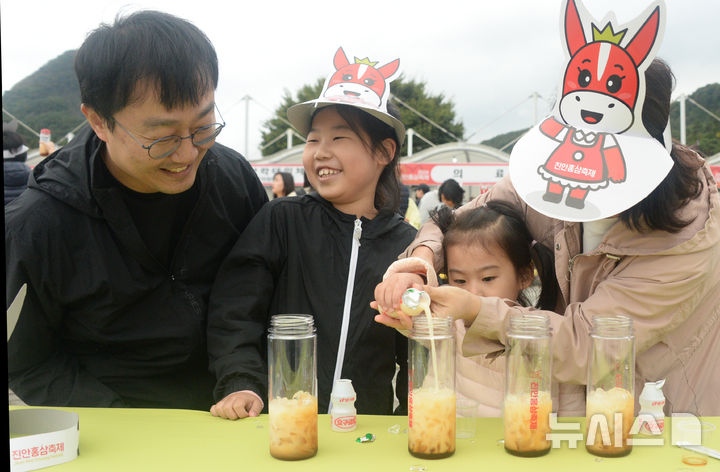 [진안=뉴시스] 김얼 기자 = 2024 진안 홍삼축제가 개막한 3일 전북 진안군 마이산 북부 특설무대를 찾은 한 가족이 진안홍삼 칵테일 만들기 체험을 하고 있다. 2024.10.03. pmkeul@newsis.com