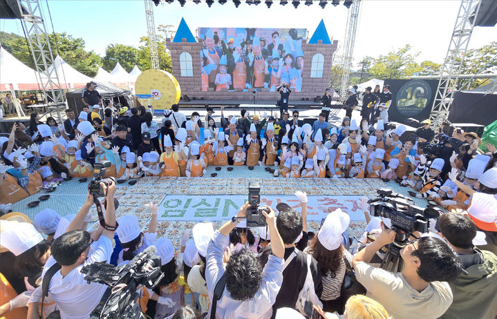 [임실=뉴시스] 김종효 기자 = '2024 임실N치즈축제' 개막 이틀째인 4일, 많은 관광객들이 한데 모여 대형 피자만들기에 도전하고 있다. (사진=임실군청 제공) 2024.10.04. photo@newsis.com *재판매 및 DB 금지