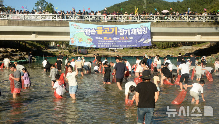 [완주=뉴시스] 김얼 기자 = '2024 완주 와일드&로컬푸드 축제' 개막일인 4일 전북 완주군 고산자연휴양림 일원 축제장을 찾은 시민들이 맨손 물고기 잡기를 하며 즐거운 시간을 보내고 있다. 2024.10.04. pmkeul@newsis.com