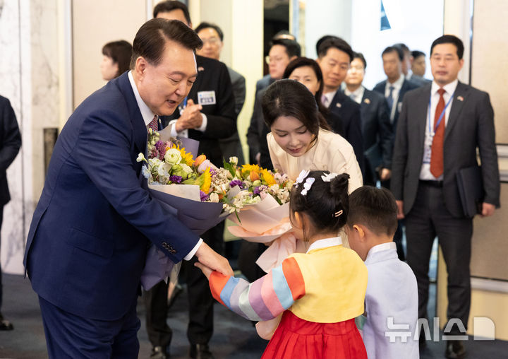 [싱가포르=뉴시스] 최진석 기자 = 윤석열 대통령과 부인 김건희 여사가 9일(현지시각) 싱가포르 샹그릴라 호텔에서 열린 싱가포르 동포 초청 오찬 간담회에서 화동으로부터 꽃다발을 받고 있다. (공동취재) 2024.10.09. myjs@newsis.com