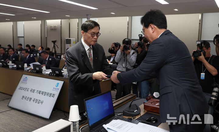 [서울=뉴시스] 김선웅 기자 = 이창용 한국은행 총재가 14일 서울 중구 한국은행 본부에서 열린 국회 기획재정위원회의 한국은행에 대한 국정감사에 출석해 증인 선서를 마친 뒤 송언석 기재위원장에게 선서문을 제출하고 있다. 2024.10.14. mangusta@newsis.com