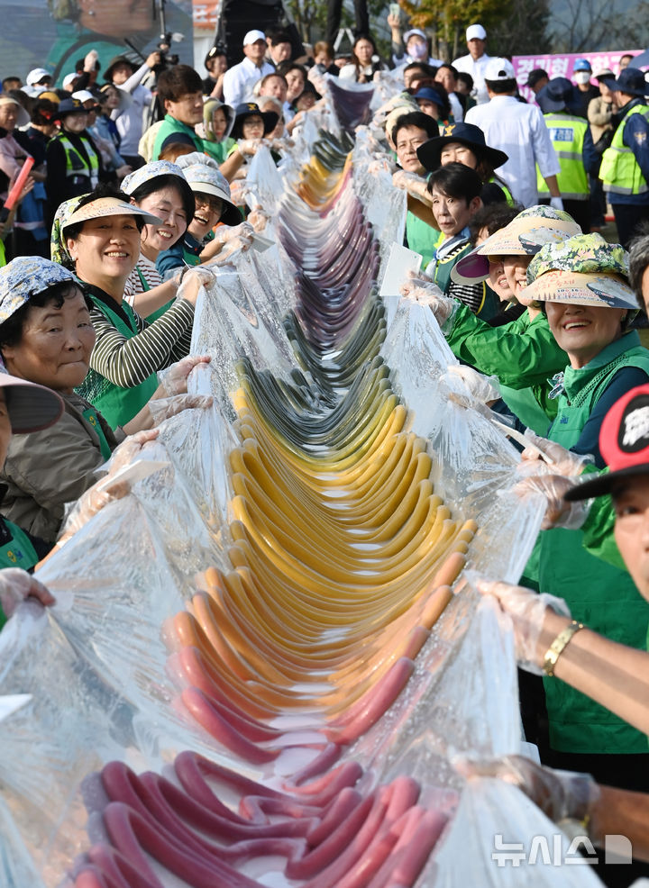 [이천=뉴시스] 김종택기자 = '제23회 이천 쌀 문화축제'가 열린 16일 경기도 이천시 모가면 이천농업테마공원에서 600m 오색 가래떡 만들기가 진행되고 있다. 2024.10.16. jtk@newsis.com