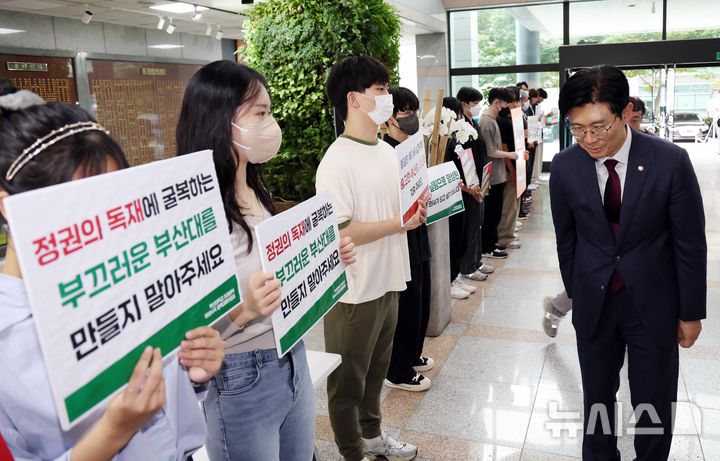 [부산=뉴시스] 하경민 기자 = 국회 교육위원회의 부산대, 경상국립대, 부산대병원, 부산대치과병원, 경상국립대병원 등 5개 기관에 대한 국정감사를 앞둔 18일 오후 부산 금정구 부산대 대학본부 로비에서 '부산대학교 의과대학 비상대책위원회' 소속 학생과 교수 등이 조건없는 휴학 승인 등을 촉구하는 피켓 시위를 연 가운데 국민의힘 조정훈 감사반장이 학생들에게 인사하고 있다. 2024.10.18. yulnetphoto@newsis.com