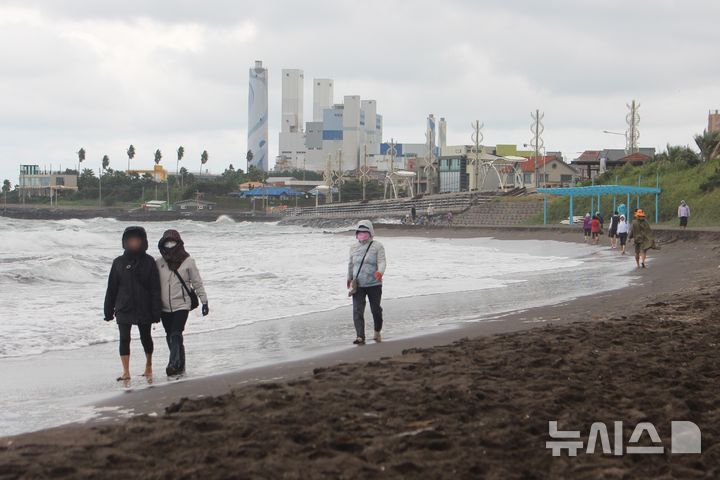 [제주=뉴시스] 양영전 기자 = 흐린 날씨를 보인 지난 19일 오후 제주시 삼양해수욕장 검은모래해변을 찾은 시민들이 맨발 걷기를 하고 있다. 2024.10.19. 0jeoni@newsis.com 