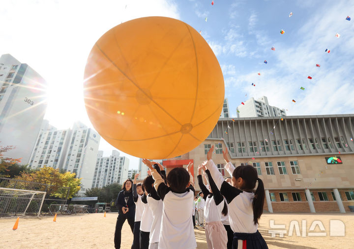 [인천=뉴시스] 전진환 기자 = 21일 오전 인천 부평구 부곡초등학교에서 열린 가을운동회에서 어린이들이 머리위로 볼 나르기를 하고 있다. 2024.10.21. amin2@newsis.com