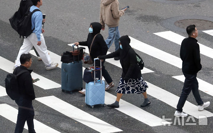 [서울=뉴시스] 추상철 기자 = 쌀쌀한 날씨를 보인 23일 오전 서울 중구 명동 인근에서 두꺼운 옷을 입은 외국인 관광객이 횡단보도를 건너고 있다. 2024.10.23. scchoo@newsis.com