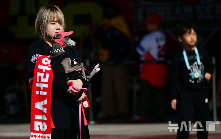 [광주=뉴시스] 이영주 기자 = 2024 KBO 포스트시즌 한국시리즈 KIA 타이거즈와 삼성 라이온즈의 1차전 서스펜디드 경기와 2차전이 열리는 23일 오후 광주 북구 광주-기아챔피언스필드에서 KIA 팬이 반려견과 함께 경기를 기다리고 있다. 2024.10.23. leeyj2578@newsis.com