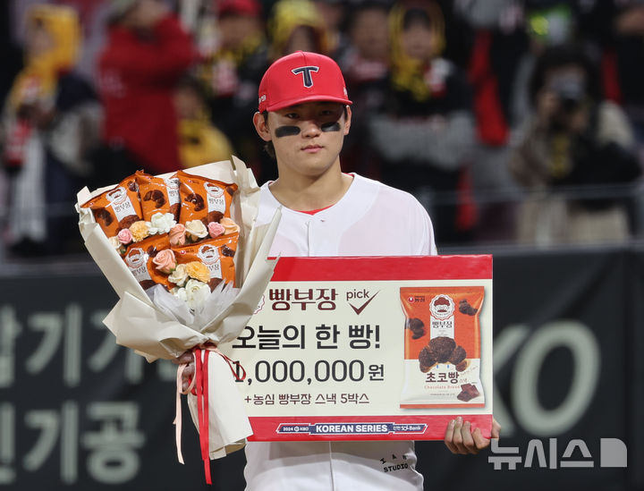 [광주=뉴시스] 김금보 기자 = 23일 광주 북구 광주-기아챔피언스필드에서 열린 2024 KBO 포스트시즌 한국시리즈 2차전 삼성 라이온즈와 KIA 타이거즈의 경기, 8-3으로 승리한 KIA 김도영이 오늘의 한 빵을 수상하고 있다. 2024.10.23. kgb@newsis.com