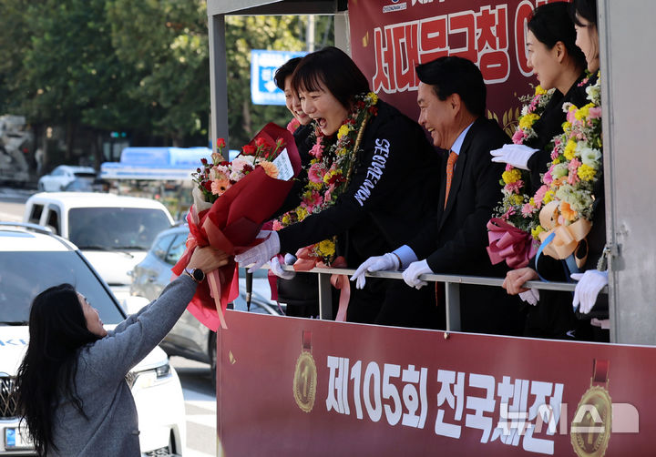 [서울=뉴시스] 이영환 기자 = 제105회 전국체육대회 농구 여자일반부에서 금메달을 차지한 서대문구청 여자농구단 박찬숙 감독이 카퍼레이드를 하며 25일 서울 서대문구 연세대학교 앞에서 시민에게 꽃다발을 받고 있다.박찬숙 감독이 이끄는 서대문구청 여자농구단은 올해 4월과 6월에 열린 2024 전국실업농구연맹전, 8월에 열린 전국남녀종별농구선수권대회, 전국체육대회까지 4개 대회 12경기 연속 무패 우승의 금자탑을 세웠다. 2024.10.25. 20hwan@newsis.com