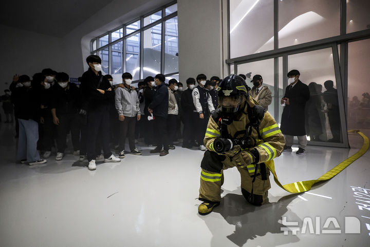 [서울=뉴시스] 정병혁 기자 = 30일 서울 중구 동대문디자인플라자에서 화재 상황을 가정해 열린 2024 서울시 재난대응 안전한국훈련에 참가한 소방대원이 화재 진화 작업을 하고 있다. 2024.10.30. jhope@newsis.com