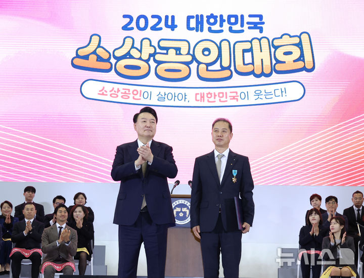 [고양=뉴시스] 조수정 기자 = 윤석열 대통령이 31일 경기 고양시 일산 킨텍스에서 열린 2024 대한민국 소상공인대회 개막식에 참석해 엘림커피 김대래 대표에게 철탑산업훈장을 수여한 뒤 기념촬영을 하고 있다. 2024.10.31. chocrystal@newsis.com