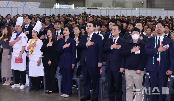 [고양=뉴시스] 조수정 기자 = 윤석열 대통령이 31일 경기 고양시 일산 킨텍스에서 열린 2024 대한민국 소상공인대회 개막식에 참석해 국기에 경례하고 있다. 왼쪽 세번째부터 김정여 궁전요리미용직업전문학교 대표, 신미소 씨인미 대표, 오영주 중소벤처기업부 장관 ,윤 대통령, 송치영 소상공인연합회장, 윤영민 달성차유리 대표 ,김주현 김주현바이각 대표.2024.10.31. chocrystal@newsis.com