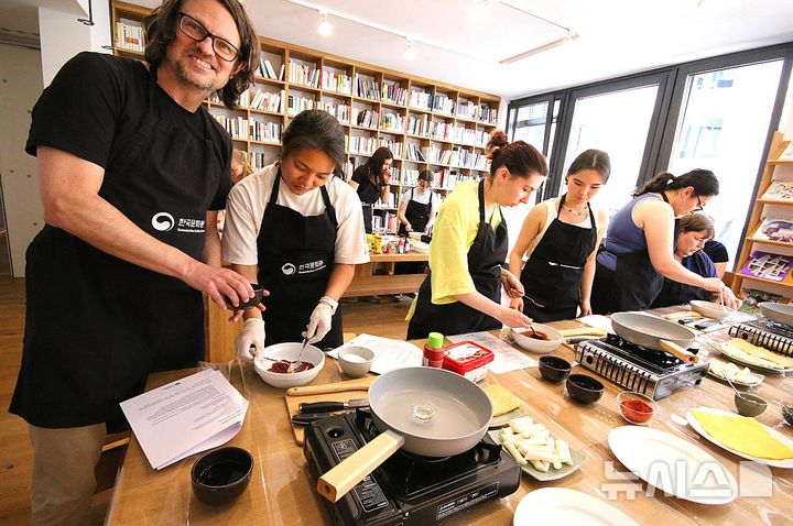 [서울=뉴시스] 주독일한국문화원 주최 한식 홍보 행사에서 김밥과 떡볶이를 직접 요리하는 독일인 참가자들. (사진=독일한국문화원 제공) photo@newsis.com *재판매 및 DB 금지