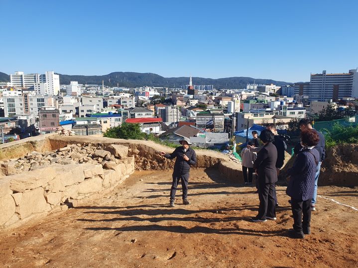 [울산=뉴시스] 구미현 기자 = 울산 중구는 6일 중구 서동 519번지 일원에서 '울산 경상좌도병영성 서남구간 일원 발굴조사' 현장 공개 행사를 열었다. 김영길 중구청장과 중구의원들이 발굴 현장 설명을 듣고 있다. 2024.11.06. gorgeouskoo@newsis.com *재판매 및 DB 금지