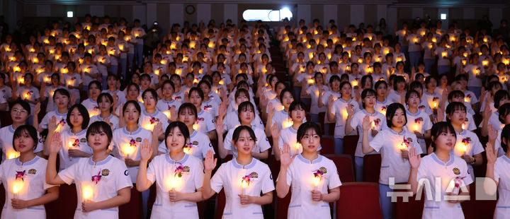 [인천=뉴시스] 전진환 기자 = 8일 오후 인천 연수구 가천대학교 메디컬캠퍼스에서 열린 제77회 나이팅게일 선서식에서 임상실습을 앞둔 간호대학 2학년 학생들이 촛불을 들고 선서를 하고 있다. 2024.11.08. amin2@newsis.com