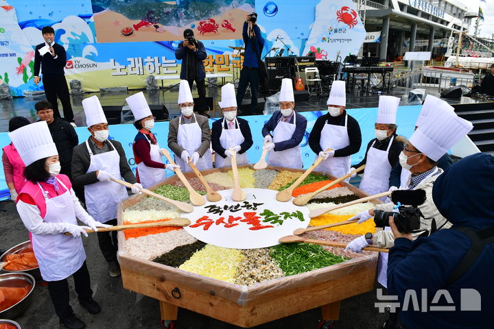 [울진=뉴시스] 송종욱 기자 = '2024 죽변항 수산물 축제'가 8~10일 사흘간 울진 죽변항 일원에서 열린 가운데 관광객이 몰려 성황을 이루고 있다. 사진은 물회 만들기 퍼포먼스 모습. (사진=울진군 제공) 2024.11.09. photo@newsis.com