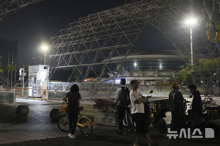 [주하이=AP/뉴시스] 11일(현지시각) 중국 광둥성 주하이의 한 체육관 앞 차량 돌진 현장 주변에 시민들이 모여 있다. 중국 남부 광둥(廣東)성 주하이(珠海)에서 11일 저녁 차량 한 대가 스포츠센터로 돌진한 사고의 사망자 수가 35명으로 증가했다. 2024.11.12.