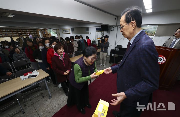 [서울=뉴시스] 김근수 기자 = 이선재(오른쪽) 일성여자중고등학교 교장이 12일 서울 마포구 일성여자중고등학교에서 열린 만학도 수능시험 합격 기원 떡 전달식에서 학생들에게 수능 합격 기원떡을 전달하고 있다. 2024.11.12. ks@newsis.com