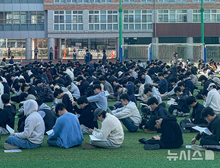 [대구=뉴시스] 정재익 기자 = 2025학년도 대학수학능력시험을 하루 앞둔 13일 대구 중구 경북대학교 사범대학 부설고등학교 운동장에서 수험생들이 수험표를 받기 위해 줄지어 앉아 있다. 2024.11.13. jjikk@newsis.com