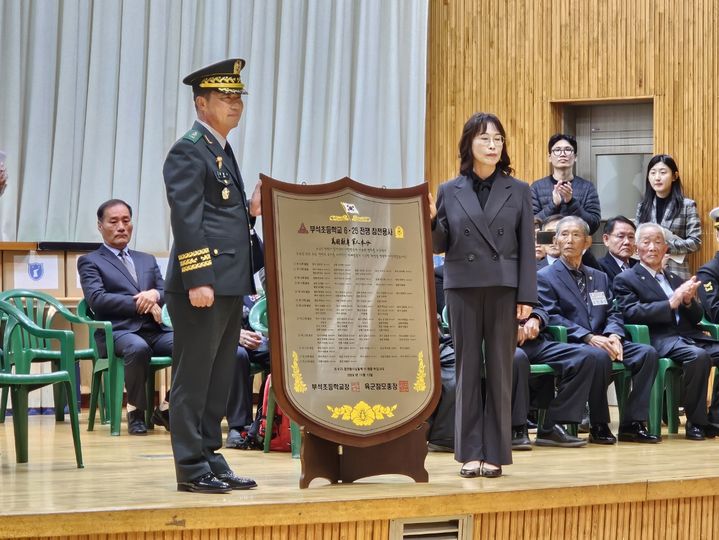 [서산=뉴시스] 김덕진 기자=13일 충남 서산 부석초등학교 웅비관에서 육군 제32보병사단 김관수 사단장이 윤병인 교장에게 '부석초등학교 6·25 참전용사 명패'를 건네며 기념 사진을 찍고 있다. 2024.11.13. spark@newsis.com *재판매 및 DB 금지