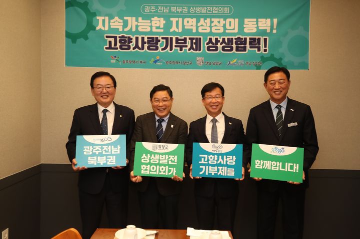 [광주=뉴시스] 14일 열린 광주전남 북부권 상생발전협의회 제8차 정례회의에서 참석자들이 고향사랑기부제 상생협력 퍼포먼스를 하고 있다. 왼쪽부터 문인 북구청장, 정광선 담양부군수, 박병규 광산구청장, 김한종 장성군수. (사진=광주 북구 제공) photo@newsis.com *재판매 및 DB 금지