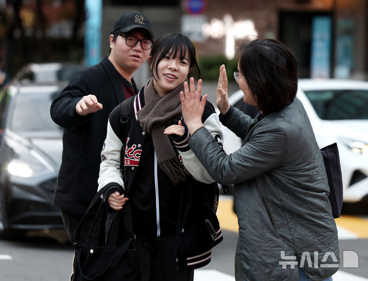 [서울=뉴시스] 김진아 기자 = 2025학년도 대학수학능력시험일인 14일 오전 서울특별시교육청 15시험지구 제20시험장이 마련된 서울 중구 이화여자외국어고등학교에서 수험생이 가족들의 응원을 받으며 입실하고 있다. 2024.11.14. bluesoda@newsis.com