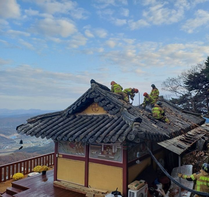 [계룡=뉴시스] 16일 오후 2시56분께 충남 계룡시 엄사면 도곡리 향적산 인근 한 암자에서 불이 나 소방대원들이 지붕에 올라가 진압하고 있다. (사진=계룡소방서 제공) 2024.11.16. photo@newsis.com *재판매 및 DB 금지