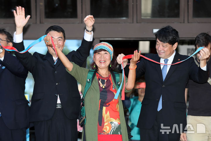 [게센누마(일본)=뉴시스] 우장호 기자 = 서명숙(가운데) ㈔제주올레 이사장이 2018년 10월7일 일본 동북지방 미야기현에서 열린 해외 세 번째 '자매의 길' 게센누마·가라쿠와 코스 개장식에서 제주올레의 표식인 리본 매듭 풀기로 축제의 시작을 알리고 있다. (뉴시스DB) woo1223@newsis.com *재판매 및 DB 금지