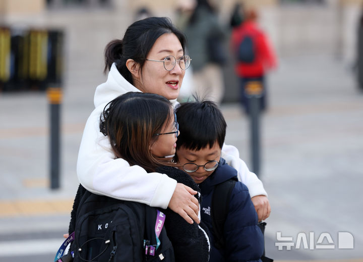 [서울=뉴시스] 김명년 기자 = 추위가 이어진 19일 오전 서울 종로구 세종대로사거리에서 아이들이 어머니 품에 안겨있다. 2024.11.19. kmn@newsis.com