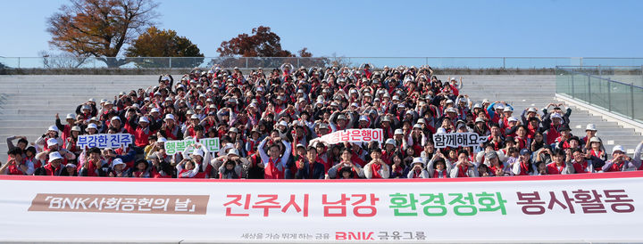 [창원=뉴시스] BNK경남은행 임직원과 가족들이 지난 16일 진주 남강 환경정화 봉사 활동 후 기념촬영을 하고 있다. (사진=BNK경남은행 제공) 2024.11.20. photo@newsis.com *재판매 및 DB 금지