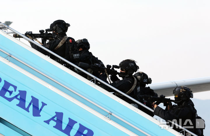 [부산=뉴시스] 하경민 기자 = '2024년도 김해국제공항 대테러 종합훈련'이 열린 20일 부산 강서구 김해국제공항에서 경찰특공대가 인질 테러범을 제압하기 위해 피랍 항공기에 진입하고 있다.   이날 훈련에는 한국공항공사 부산본부, 국가정보원, 부산지방항공청, 국군방첩사령부, 부산경찰청, 공군 제5공중기동비행단, 대한항공 등 12개 기관 120여 명이 참여했으며, 대한항공 A321 여객기를 비롯해 폭발물처리차량, 군 장갑차 등 25종 29대 장비가 동원됐다. 2024.11.20. yulnetphoto@newsis.com