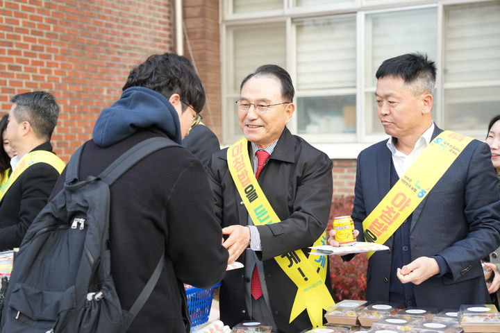 [천안=뉴시스] 21일 천안중앙고등학교에서 박상돈 천안시장과 조승국 NH농협 천안시지부장이 등굣길 학생을 대상으로 떡과 쌀 음료 등을 나눠 주고 있다. (사진=천안시 제공) 2024.11.21 photo@newsis.com *재판매 및 DB 금지