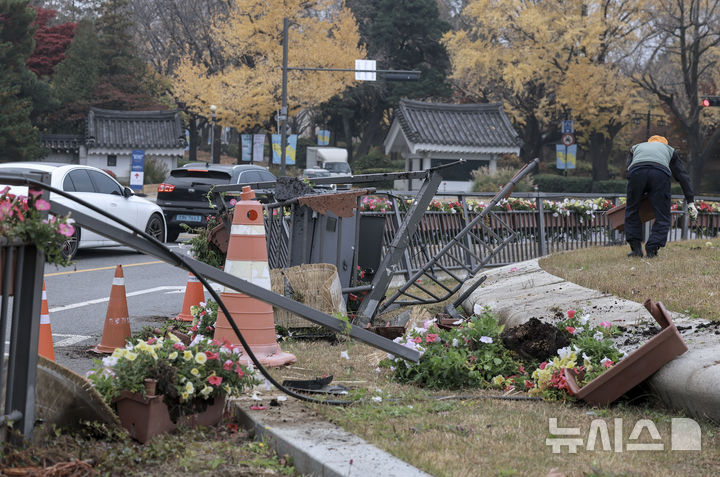 [서울=뉴시스] 정병혁 기자 = 21일 오전 0시 15분쯤 10대 후반 남성이 운전하던 승용차가 돌진해 발생한 서울 종로구 청와대 앞 분수광장 사고현장에서 관계자가 부서진 화단과 울타리 등을 정리하고 있다. 2024.11.21. jhope@newsis.com