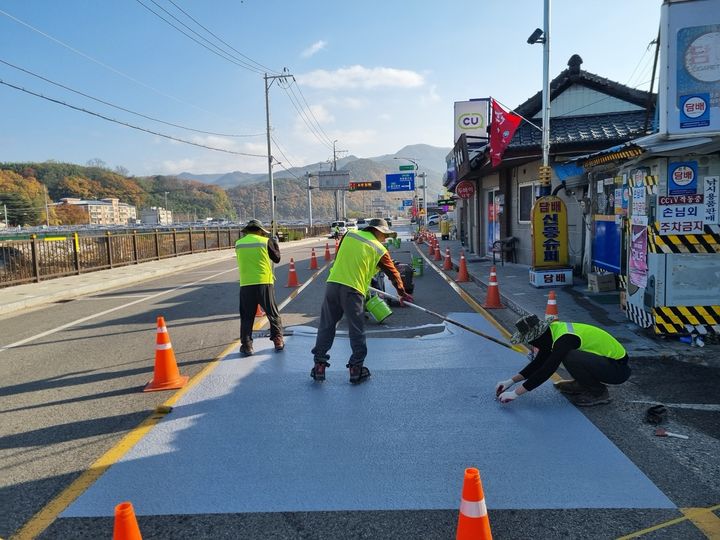 [영동=뉴시스] 충북 영동군 황간면 군도 24호선에 차열도색제를 도포하는 모습. (사진=영동군 제공) 2024.11.22. photo@newsis.com *재판매 및 DB 금지