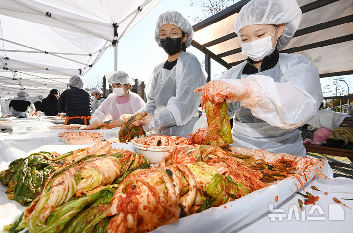 [수원=뉴시스] 김종택기자 = 김치의 날인 22일 경기도 수원시 권선구 국립농업박물관에서 열린 '사랑의 김장 나눔 행사'에서 수원 구운초등학교 학생들이 소외계층에 전달하기 위해 김치를 담그고 있다. 2024.11.22. jtk@newsis.com