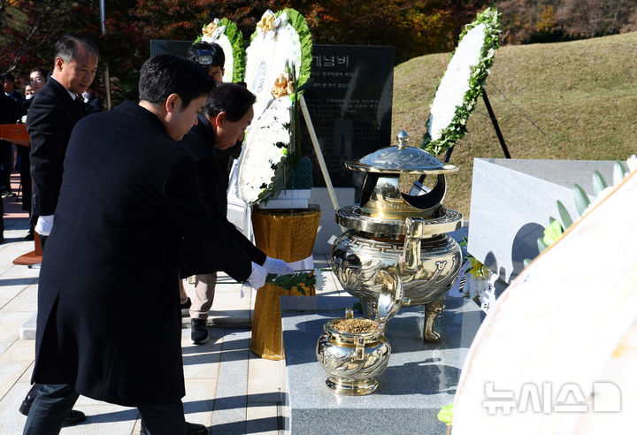 [서울=뉴시스] 전신 기자 = 22일 서울 동작구 국립서울현충원에서 열린 고 김영삼 전 대통령 서거 9주기 추모식을 마친 김현철 김영삼대통령기념재단 이사장과 손자 김인규 대통령실 행정관이 묘역을 찾아 참배하고 있다. 2024.11.22. photo1006@newsis.com