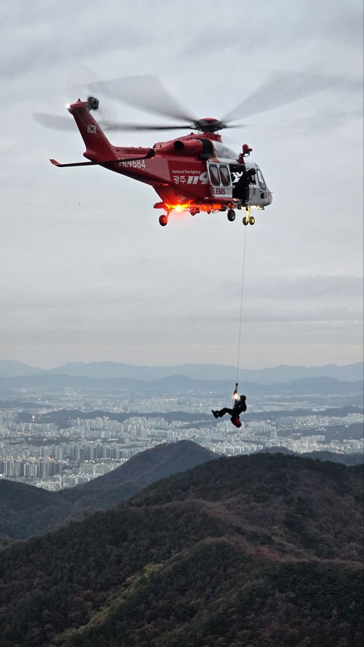 [광주=뉴시스] 산지 조난자 구조를 위해 출동한 광주시소방본부 소방헬기에서 내려오는 구조대원. (사진=광주시소방본부 제공)2024.11.24. photo@newsis.com *재판매 및 DB 금지