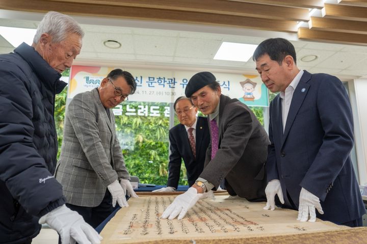 [증평=뉴시스] 27일 충북 증평군 증평읍 송산리 '독서왕 김득신문학관'에서 이재영(오른쪽) 군수 등이 기증 유물을 살피고 있다. 괴산군 소수면에 거주하는 김만응(왼쪽)씨는 17세기 말 양자문서 1점과 호구단자 10점, 토지매매 명문 1점, 묘지 관련 자료인 소지(所志) 1점 등 고문서 13점을 기증했다. (사진=증평군 제공) 2024.11.27. photo.newsis.com *재판매 및 DB 금지