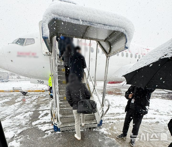 [제주=뉴시스] 많은 눈이 내린 27일 김포공항에서 공항 이용객들이 제주행 여객기에 탑승하고 있다. (사진=독자 제공) 2024.11.27. photo@newsis.com