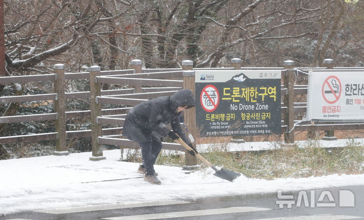 [제주=뉴시스] 우장호 기자 = 올 겨울 들어 제주 지역에 첫눈이 내린 27일 오전 한라산국립공원 1100고지 습지 탐방안내소 관계자가 쌓인 눈을 치우고 있다. 2024.11.27. woo1223@newsis.com