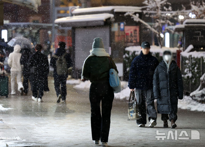 [서울=뉴시스] 김선웅 기자 = 목요일인 28일은 전국 대부분 지역에 눈이나 비가 오겠고 특히 중부지방을 중심으로 많은 눈이 내리겠다. 사진은 서울에 많은 눈이 내린 전날 오후 서울역 인근에서 시민들이 내리는 눈 사이를 걷고 있는 모습. 2024.11.27. mangusta@newsis.com