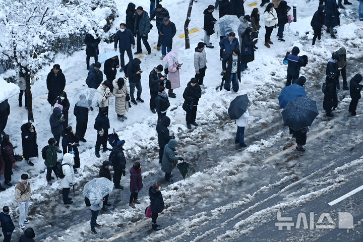 [수원=뉴시스] 김종택 기자 = 수도권 지역에 많은 눈이 내린 28일 경기도 수원시 영통구 망포동 한 버스정류장에서 출근길 시민들이 버스를 기다리고 있다. 2024.11.28. jtk@newsis.com