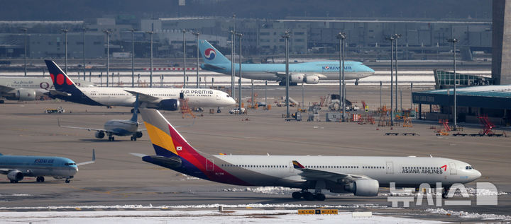 [인천공항=뉴시스] 김선웅 기자 = 대한항공이 아시아나항공과의 기업결합을 위해 유럽연합(EU) 경쟁당국이 제시한 조건부 승인의 선행 조건을 모두 충족하며 28일 사실상 인수 작업 마무리 수순에 들어갔다.  미국 법무부(DOJ)의 심사가 남았지만 양사 합병에 대해 독과점 소송을 제기하지 않는다면 승인으로 간주한다. 대한항공은 미국 DOJ에 EU 경쟁당국의 최종 승인 내용을 보고한 상태다. 지난 2021년 1월 기업결합을 위해 나선 지 약 4년 만이다. 29일 인천국제공항 활주로에서 대한항공·아시아나항공 양사 항공기가 오가고 있다. 2024.11.29. mangusta@newsis.com