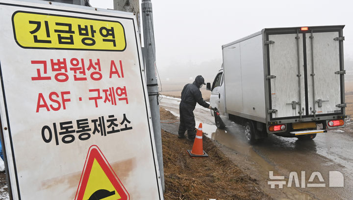[여주=뉴시스] 김종택 기자 = 사진은 지난 6일 고병원성 조류인플루엔자(AI)가 발생한 경기도 여주시 흥천면 한 산란계 농장 인근 이동통제초소에서 방역 관계자가 차량 방역작업을 하고 있는 모습. 2025.01.06. jtk@newsis.com